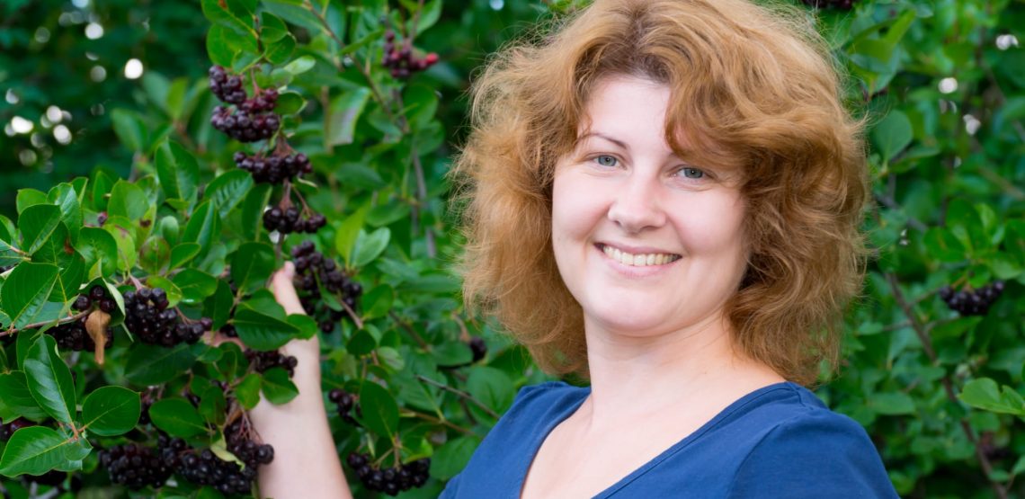 Smiling woman showing aronia berries