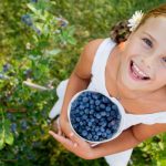 Young child holding a basket of Blueberries
